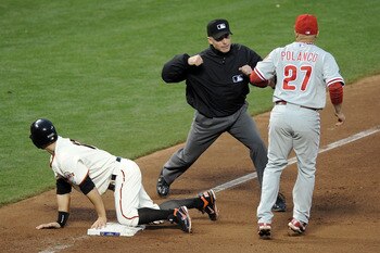 SAN FRANCISCO - OCTOBER 21:  Umpire Dan Iassogna calls out Cody Ross #13 of the San Francisco Giants as he is tagged by Placido Polanco #27 of the Philadelphia Phillies in the fourth inning in Game Five of the NLCS during the 2010 MLB Playoffs at AT&T Par