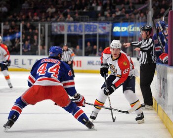 NEW YORK, NY - JANUARY 25: Steve Eminger #44 of the New York Rangers and Rostislav Olesz #85 of the Florida Panthers play for possession of the puck along the boards during the first period at Madison Square Garden on January 25, 2011 in New York City. (P