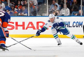 UNIONDALE, NY - JANUARY 11:  Raffi Torres #13 of the Vancouver Canucks tries to poke check the puck during an NHL game against the New York Islanders at Nassau Coliseum on January 11, 2011 in Uniondale, New York.  (Photo by Paul Bereswill/Getty Images)