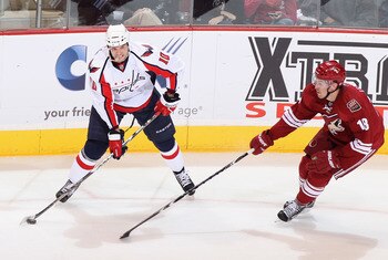 GLENDALE, AZ - FEBRUARY 14:  Matt Bradley #10 of the Washington Capitals looks to pass the puck under pressure from Sami Lepisto #18 of the Phoenix Coyotes during the NHL game at Jobing.com Arena on February 14, 2011 in Glendale, Arizona.  (Photo by Chris