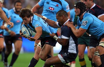 MELBOURNE, AUSTRALIA - FEBRUARY 18:  Luke Burgess of the Waratahs is tackled during the round one Super Rugby match between the Melbourne Rebels and the Waratahs at AAMI Park on February 18, 2011 in Melbourne, Australia.  (Photo by Scott Barbour/Getty Ima