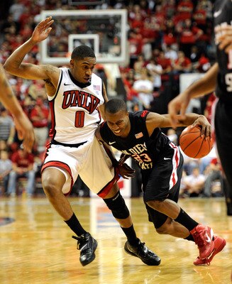 LAS VEGAS, NV - FEBRUARY 12:  D.J. Gay #23 of the San Diego State Aztecs drives against Oscar Bellfield #0 of the UNLV Rebels during their game at the Thomas & Mack Center February 12, 2011 in Las Vegas, Nevada. San Diego State won 63-57.  (Photo by Ethan