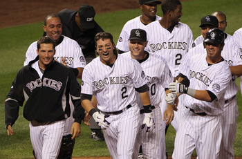 DENVER - SEPTEMBER 25:  Troy Tulowitzki #2 of the Colorado Rockies celebrates with Huston Street (L) and their teammates after he hit the game RBI double to score Carlos Gonzalez #5 against the San Francisco Giants in the 10th inning at Coors Field on Sep