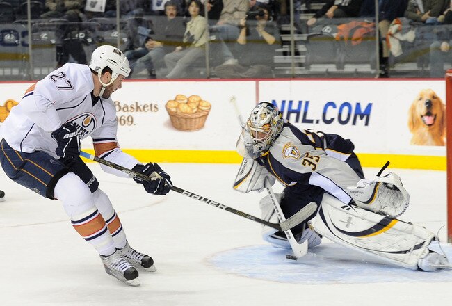 NASHVILLE, TN - FEBRUARY 07:  Pekka Rinne #35 of the Nashville Predators makes a save on Dustin Penner #27 of the Edmonton Oilers on February 7, 2011 at the Bridgestone Arena in Nashville, Tennessee.  (Photo by Frederick Breedon/Getty Images)