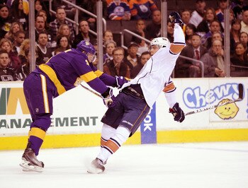 LOS ANGELES, CA - JANUARY 15:  Magnus Paajarvi #91 of the Edmonton Oilers is knocked off balance by Jack Johnson #3 of the Los Angeles Kings during the first period at the Staples Center on January 15, 2011 in Los Angeles, California.  (Photo by Harry How