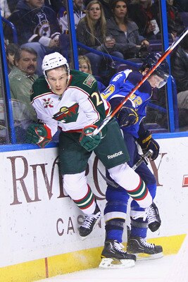 ST. LOUIS, MO - FEBRUARY 11: Chuck Kobasew #12 of the Minnesota Wild is checked into the boards by David Backes #42 of the St. Louis Blues at the Scottrade Center on February 11, 2011 in St. Louis, Missouri.  (Photo by Dilip Vishwanat/Getty Images)
