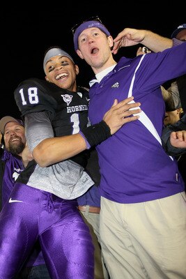 PASADENA, CA - JANUARY 01:  Cornerback Travaras Battle #18 of the TCU Horned Frogs celebrates with a fan after defeating the Wisconsin Badgers 21-19 in the 97th Rose Bowl game on January 1, 2011 in Pasadena, California.  (Photo by Stephen Dunn/Getty Image