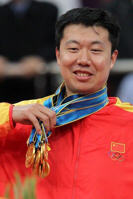 GUANGZHOU, CHINA - NOVEMBER 26:  Wang Zhizhi #14 of China is given all the medals by his teammates to wear after China wins the gold medal by defeating South Korea 77-71 in the men's gold medal basketball game at the Guangzhou International Sports Arena d