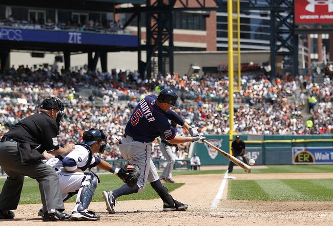 DETROIT - JULY 11: Michael Cuddyer #5 of the Minnesota Twins doubles to deep left center field in the fifth inning scoring Denard Span #2 and Delmon Young #21 during the game against the Detroit Tigers on July 11, 2010 at Comerica Park in Detroit, Michiga