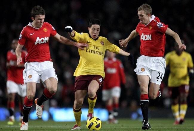 MANCHESTER, ENGLAND - DECEMBER 13:  Samir Nasri of Arsenal competes with Darren Fletcher (R) and Michael Carrick of Manchester United during the Barclays Premier League match between Manchester United and Arsenal at Old Trafford on December 13, 2010 in Ma