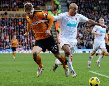 WOLVERHAMPTON, ENGLAND - FEBRUARY 26:  Kevin Doyle of Wolves (L) in action with Alex Baptiste of Blackpool during the Barclays Premier League match between Wolverhampton Wanderers and Blackpool at Molineux on February 26, 2011 in Wolverhampton, England.