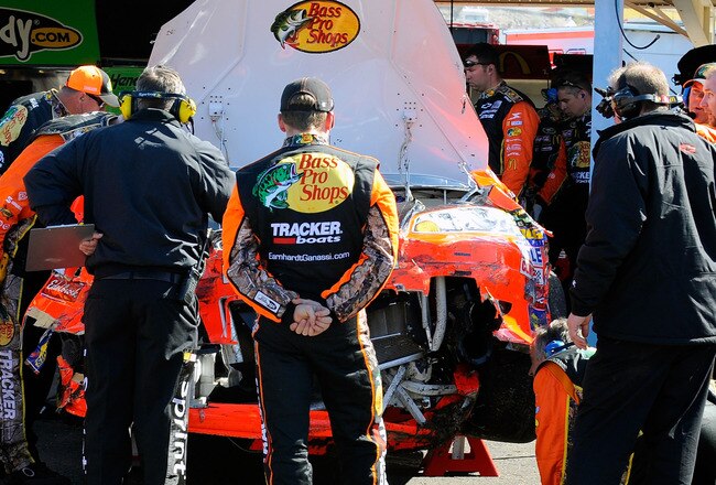 AVONDALE, AZ - FEBRUARY 27:  Jamie McMurray, driver of the #1 Bass Pro Shops Chevrolet, looks on as crew members repair damage to his car after a crash during the NASCAR Sprint Cup Series Subway Fresh Fit 500 at Phoenix International Raceway on February 2