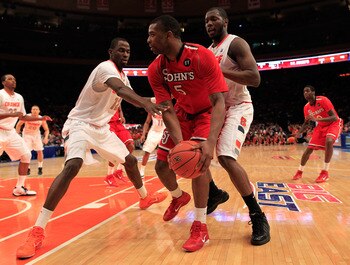 NEW YORK, NY - MARCH 10: Sean Evans #5 of the St. John's Red Storm looks to pass against Baye Moussa Keita #12 and Rick Jackson #00 of the Syracuse Orange during the quarterfinals of the 2011 Big East Men's Basketball Tournament presented by American Eagl