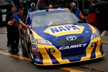 DAYTONA BEACH, FL - FEBRUARY 16:  Crew members push the #56 NAPA Toyota of Martin Truex Jr. during a rain delay in the garage area during practice for the NASCAR Nationwide Series DRIVE4COPD 300 at Daytona International Speedway February 16, 2011 in Dayto
