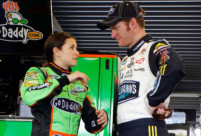 DAYTONA BEACH, FL - FEBRUARY 17:  Danica Patrick (L), driver of the #7 GoDaddy.com Chevrolet, talks with Dale Earnhardt Jr. (R), driver of the #5 Hellmann's Chevrolet, in the garage during practice for the NASCAR Nationwide Series DRIVE4COPD 300 at Dayton