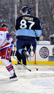 PITTSBURGH, PA - JANUARY 01:  Sidney Crosby #87 of the Pittsburgh Penguins jumps to get out of the way as Semyon Varlamov #1 of the Washington Capitals defends the net during the 2011 NHL Bridgestone Winter Classic at Heinz Field on January 1, 2011 in Pit