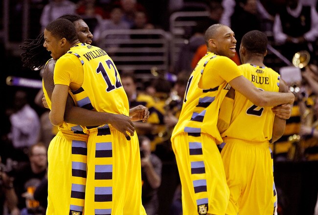 CLEVELAND, OH - MARCH 20:  Jae Crowder #32, Erik Williams #12, Joseph Fulce #21 and Vander Blue #2 of the Marquette Golden Eagles hug after defeating the Syracuse Orange during the third of the 2011 NCAA men's basketball tournament at Quicken Loans Arena