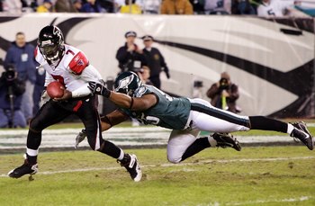 PHILADELPHIA - DECEMBER 31:  Michael Vick #7 of the Atlanta Falcons eludes a tackle by Jerome McDougle #95 of the Philadelphia Eagles in NFL action December 31, 2006 at Lincoln Financial Field in Philadelphia, Pennsylvania. The Eagles won 24-17.  (Photo b