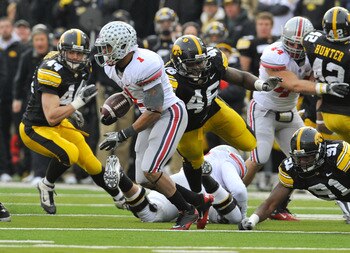IOWA CITY, IA - NOVEMBER 20:  Tailback Dan Herron #1 of the Ohio State Buckeyes scrambles for yards past defensive end Christian Ballard $46 of the University of Iowa Hawkeyes during the second half of play at Kinnick Stadium on November 20, 2010 in Iowa