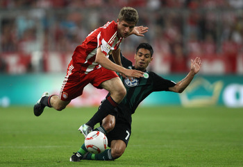 MUNICH, GERMANY - AUGUST 20: Thomas Mueller of Bayern is tackled by Josue of Wolfsburg during the Bundesliga match between FC Bayern Muenchen and VfL Wolfsburg at Allianz Arena on August 20, 2010 in Munich, Germany. (Photo by Clive Brunskill/Getty Image