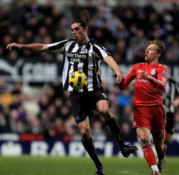 NEWCASTLE UPON TYNE, ENGLAND - DECEMBER 11:  Andy Carroll of Newcastle United competes with Lucas of Liverpool during the Barclays Premier League match between Newcastle United and Liverpool at St James' Park on December 11, 2010 in Newcastle, England.  (