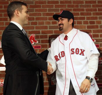BOSTON, MA - DECEMBER 06:  Adrian Gonzalez (R) shakes hands with Boston Red Sox General Manager Theo Epstein after it was announced that Gonzalez signed with the Boston Red Sox on December 6,  2010 at Fenway Park in Boston, Massachusetts.  (Photo by Elsa/