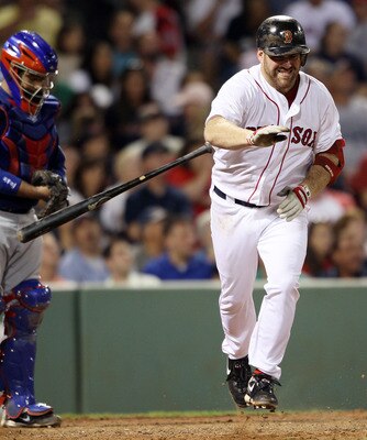 BOSTON - JULY 15:  Kevin Youkilis #20 of the Boston Red Sox reacts after hitting a pop fly out as Bengie Molina #11 of the Texas Rangers defends on July 15, 2010 at Fenway Park in Boston, Massachusetts.  (Photo by Elsa/Getty Images)