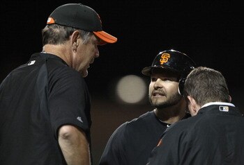 GLENDALE, AZ - MARCH 04:  Cody Ross #13 of the San Francisco Giants talks with manager Bruce Bochy  after Ross was hit by a pitch during the second inning of the spring training game against the Los Angeles Dodgers at Camelback Ranch on March 4, 2011 in G