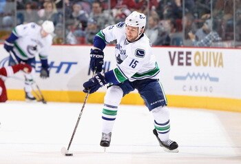 GLENDALE, AZ - FEBRUARY 02:  Tanner Glass #15 of the Vancouver Canucks skates with the puck during the NHL game against the Phoenix Coyotes at Jobing.com Arena on February 2, 2011 in Glendale, Arizona.  The Canucks defeated the Coyotes 6-0.  (Photo by Chr