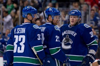 VANCOUVER, CANADA - MARCH 31: Daniel Sedin #22 of the Vancouver Canucks is congratulated by Henrik Sedin #33 and Victor Oreskovich #38 after scoring against the Los Angeles Kings during the second period in NHL action on March 31, 2011 at Rogers Arena in