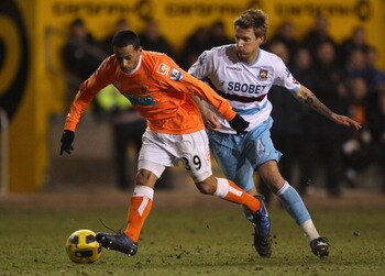 BLACKPOOL, ENGLAND - FEBRUARY 02: DJ Campbell of Blackpool beats Rodoslav Kovac of West Ham United during the Barclays Premier League match between Blackpool and West Ham United at Bloomfield Road on February 2, 2011 in Blackpool, England. (Photo by Ale