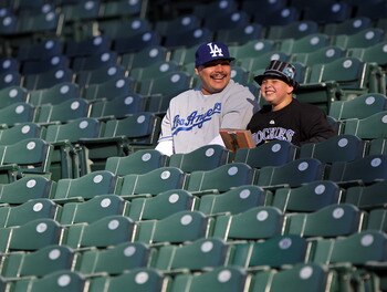 DENVER, CO - APRIL 05:  Michael Guerro (L) and his son Isaiah Alvarez, 10, get early seats as their prepare to support their teams as the Colorado Rockies host the Los Angeles Dodgers at Coors Field on April 5, 2011 in Denver, Colorado.  (Photo by Doug Pe