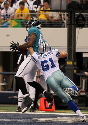 ARLINGTON, TX - OCTOBER 31:  Marcedes Lewis #89 of the Jacksonville Jaguars catches a 9-yard touchdown reception in the third quarter against Keith Brooking #51 of the Dallas Cowboys at Cowboys Stadium on October 31, 2010 in Arlington, Texas.  (Photo by S
