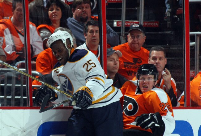 PHILADELPHIA, PA - APRIL 14: Mike Grier #25 of the Buffalo Sabres hits Danny Syvret #26 of the Philadelphia Flyers into the boards in Game One of the Eastern Conference Quarterfinals during the 2011 NHL Stanley Cup Playoffs at Wells Fargo Center on April