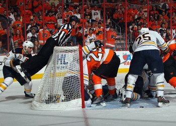 PHILADELPHIA, PA - APRIL 14: Referee Kelly Sutherland #11 climbs on the back of the net to get a better view of the play between the Philadelphia Flyers and the Buffalo Sabres in Game One of the Eastern Conference Quarterfinals during the 2011 NHL Stanley