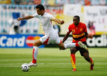 LEIPZIG, GERMANY - JUNE 21: Ali Daei of Iran skips past Mateus of Angola during the FIFA World Cup Germany 2006 Group D match between Iran and Angola played at the Zentralstadion on June 21, 2006 in Leipzig, Germany. (Photo by Shaun Botterill/Getty Images