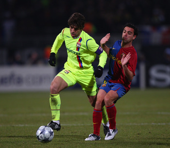 LYON, FRANCE - FEBRUARY 24:  Juninho (l) of Lyon challenged by Xavi Hernandez (r) during the UEFA Champions League First Knock -out round, first Leg match between Lyon and Barcelona at the Stade de Gerland on February 24, 2009 in Lyon, France.  (Photo by 