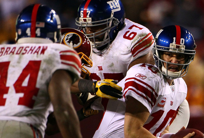 LANDOVER, MD - JANUARY 02:  Quarterback Eli Manning #10 of the New York Giants looks to Ahmad Bradshaw to lateral the ball while being pressured by the Washington Redskins defense during their game at FedEx Field on January 2, 2011 in Landover, Maryland.