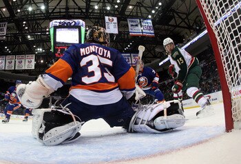 UNIONDALE, NY - MARCH 02:  Al Montoya #35 of the New York Islanders makes the save as Andrew Brunette #15 of the Minnesota Wild looks for a rebound at the Nassau Coliseum on March 2, 2011 in Uniondale, New York.  (Photo by Bruce Bennett/Getty Images)