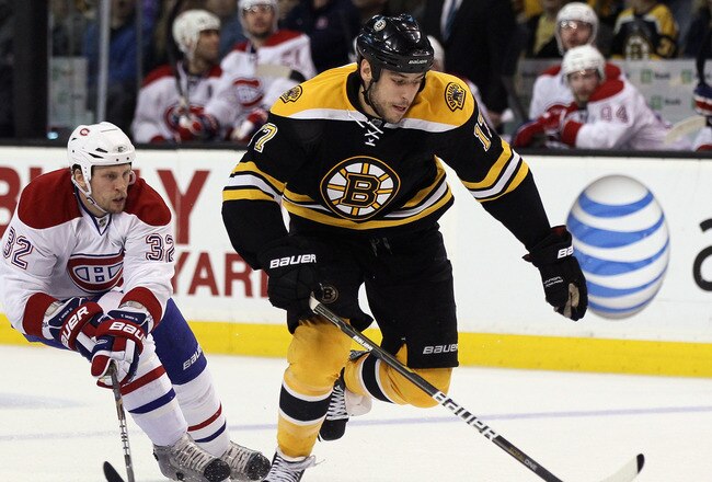 BOSTON, MA - APRIL 23:  Milan Lucic #17 of the Boston Bruins takes the puck as Travis Moen #32 of the Montreal Canadiens defends in Game Five of the Eastern Conference Quarterfinals during the 2011 NHL Stanley Cup Playoffs at TD Garden on April 23, 2011 i