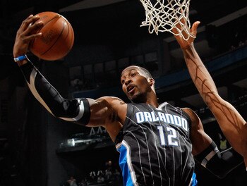 ATLANTA, GA - APRIL 24:  Dwight Howard #12 of the Orlando Magic grabs a rebound against Jason Collins #34 of the Atlanta Hawks during Game Four of the Eastern Conference Quarterfinals in the 2011 NBA Playoffs at Philips Arena on April 24, 2011 in Atlanta,