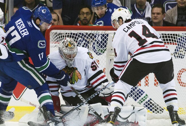 VANCOUVER, CANADA - APRIL 26: Ryan Kesler #17 of the Vancouver Canucks tips the puck towards goalie Corey Crawford #50 of the Chicago Blackhawks while being watched by Chris Campoli #14 of the Chicago Blackhawks during the first period in Game Seven of th