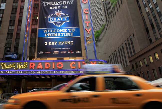 NEW YORK, NY - APRIL 28:  Taxi cabs drive down the Avenue of the Americas past the Radio City Music Hall marquee, site of the 2011 NFL Draft, on April 28, 2011 in New York City.  (Photo by Chris Trotman/Getty Images)