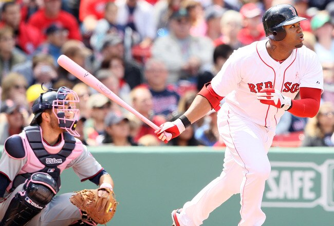 BOSTON, MA - MAY 08:  Carl Crawford #13 of the Boston Red Sox hits a triple as Drew Butera #41 of the Minnesota Twins catches on May 8, 2011 at Fenway Park in Boston, Massachusetts. The Minnesota Twins and the Boston Red Sox wore pink and used pink bats i