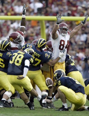 PASADENA, CA - JANUARY 1:  Placekicker Garrett Rivas #38 of the Michigan Wolverines attempts a field goal which was blocked by defensive tackle Shaun Cody #84 of the USC Trojans during the 2004 Rose Bowl game on January 1, 2004 at the Rose Bowl in Pasaden