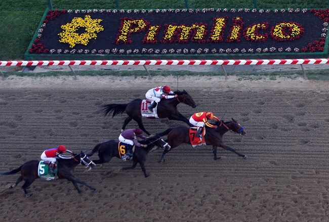 BALTIMORE - MAY 15:  Lookin At Lucky (center), ridden by Martin Garcia #7, holds off First Dude, ridden by Ramon Dominguez #11, Jackson Bend , ridden by Mike Smith #6, and Yawanna Twist, ridden by Edgar Prado #5, down the homestrech to win the 135th runni