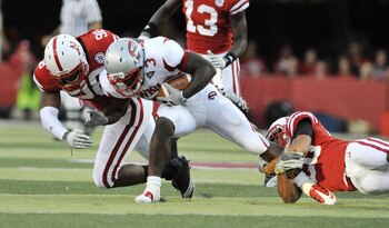 LINCOLN, NE - SEPTEMBER 04:  Bobby Rainey #3 of the Western Kentucky Hilltoppers gets brought down by Josh Williams #98 and Eric Hagg #28 of the Nebraska Cornhuskers during first half action of their game at Memorial Stadium on September 4, 2010 in Lincol