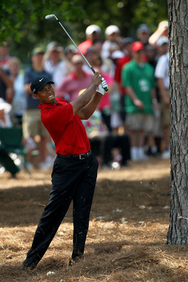 AUGUSTA, GA - APRIL 10:  Tiger Woods hits from the pine needles during the final round of the 2011 Masters Tournament at Augusta National Golf Club on April 10, 2011 in Augusta, Georgia.  (Photo by Jamie Squire/Getty Images)