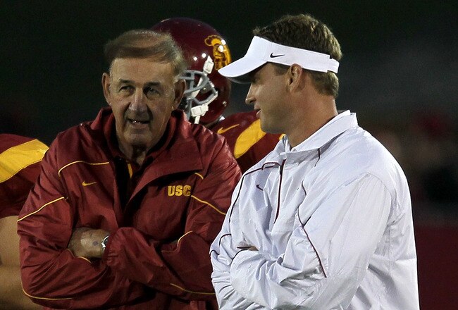 LOS ANGELES, CA - SEPTEMBER 11:  Head coach Lane Kiffin (R) and his father and defensive coordinator Monte Kiffin of the USC Trojans  talk during warmups for their game with the Virginia Cavaliers at Los Angeles Memorial Coliseum on September 11, 2010 in