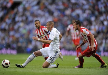 MADRID, SPAIN - MAY 21:  Karim Benzema (L) of Real Madrid passes the ball beside Rigo of UD Almeria during the La Liga match between Real Madrid and UD Almeria at Estadio Santiago Bernabeu on May 21, 2011 in Madrid, Spain.  (Photo by Denis Doyle/Getty Ima